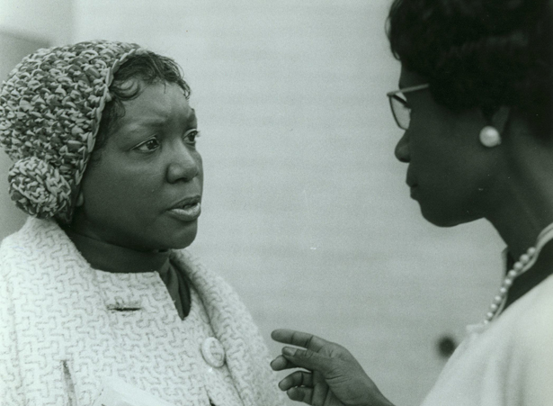 Two women speak to each other.